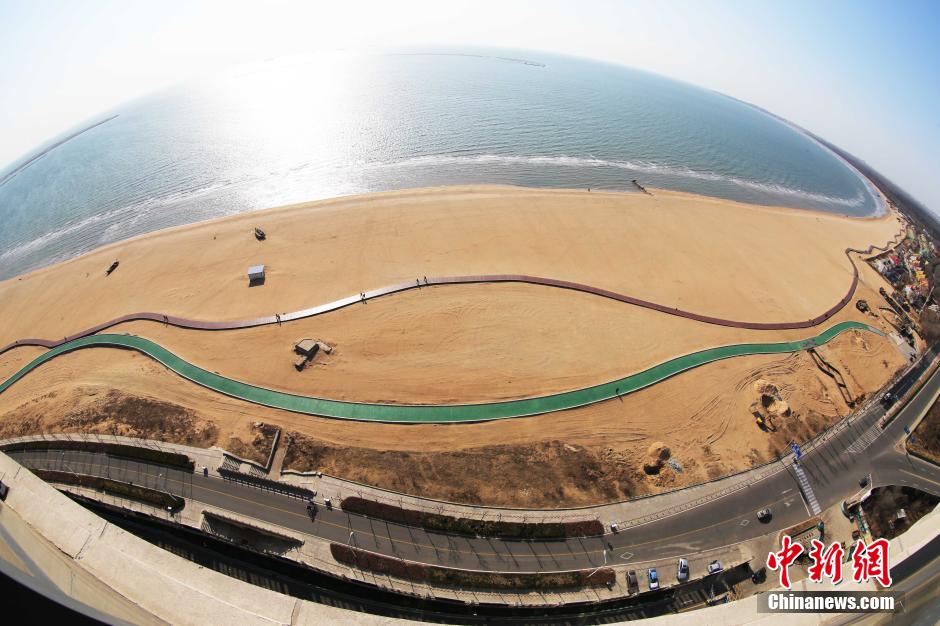 3月13日，秦皇島萬(wàn)米臨海沙灘木棧道。據(jù)了解，該木棧道全長(zhǎng)約4200米，與北戴河區(qū)原有的7500米木棧道對(duì)接后全線總長(zhǎng)度1.17萬(wàn)米，整個(gè)木棧道東起秦皇島體育基地游船碼頭，西至北戴河濕地公園，呈波浪形蜿蜒10.4公里海岸線。 中新社發(fā) 曹建雄 攝 CNSPHOTO